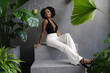 © Creative Flame - Elegant young African American woman sitting on steps among plants