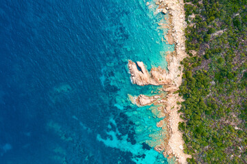 Wall Mural - View from above, stunning aerial view of a green and rocky coastline bathed by a turquoise, crystal clear water. Costa Smeralda, Sardinia, Italy.