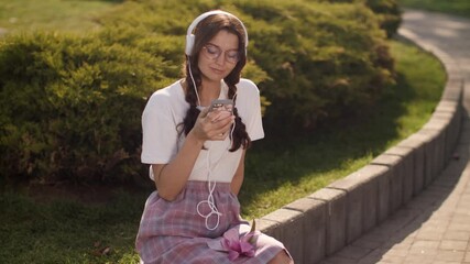 Wall Mural - Woman With Smartphone and Headphones Outdoors in the City Park