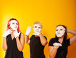 © Marina Chernivetskay - girls in white masks and white gloves in the image of mimes an unseen wall show hands actors of theater and cinema, the concept of advertising a shopping center