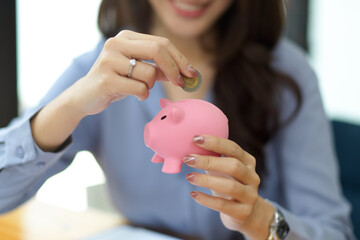 Sticker - Beautiful woman holding and putting coin in piggy bank