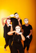 © Marina Chernivetskay - girls in white masks and white gloves in the image of mimes an unseen wall show hands actors of theater and cinema, the concept of advertising a shopping center
