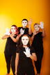 © Marina Chernivetskay - girls in white masks and white gloves in the image of mimes an unseen wall show hands actors of theater and cinema, the concept of advertising a shopping center