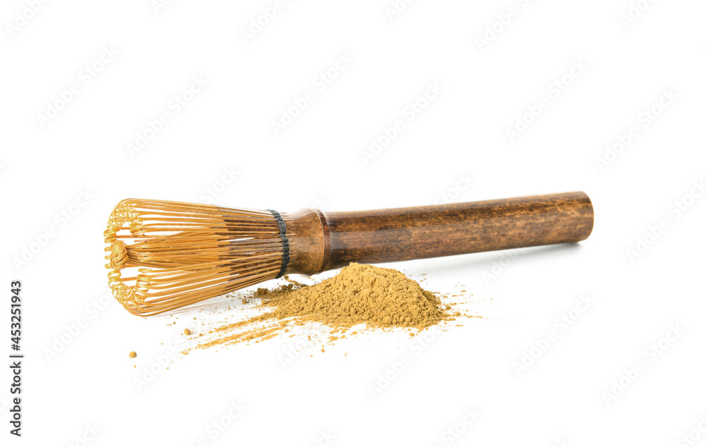 Heap of powdered matcha tea and chasen on white background