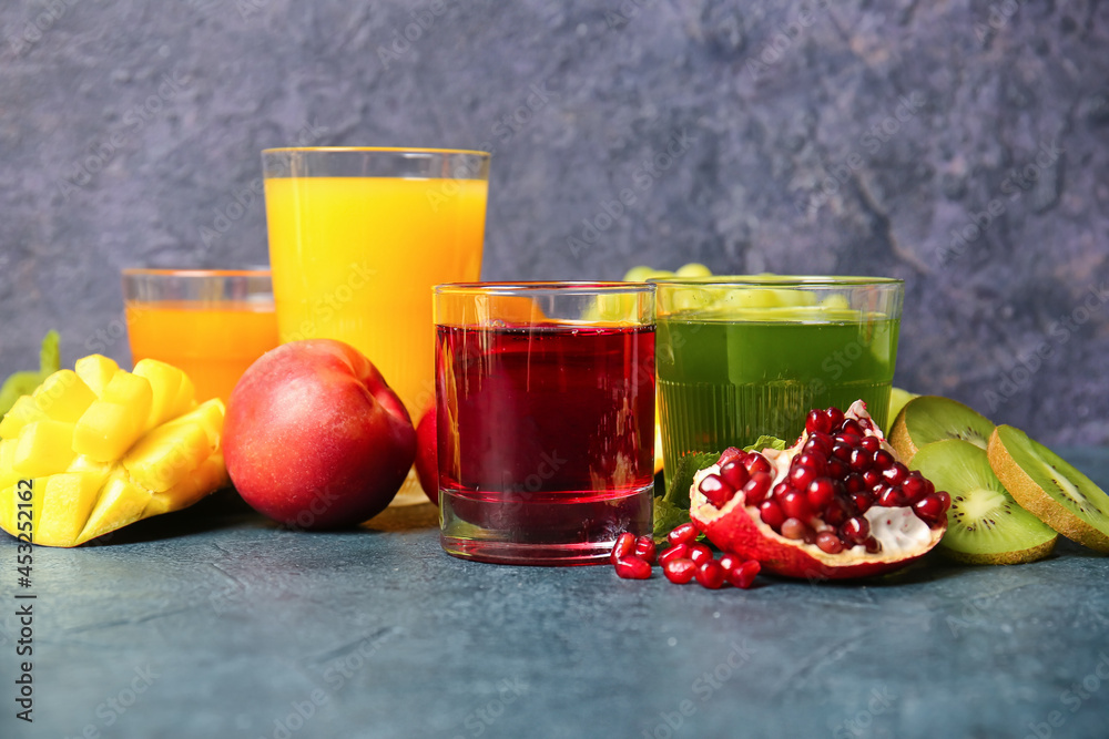 Glasses with healthy juice, fruits and vegetables on dark background