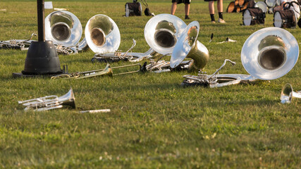 Wall Mural - several sousaphones and other brass instruments resting during a water break