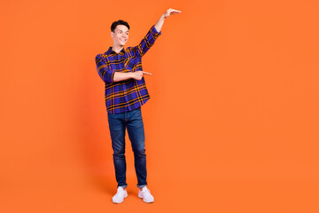 Sticker - Full body photo of young funny guy point wear shirt jeans sneakers isolated on orange background