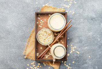 Wall Mural - Plant based oat flakes milk, non dairy vegan alternative drink in glass, top view, negative space