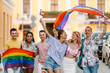 © Drobot Dean - Multiracial men and women walking with rainbow flags during pride parade