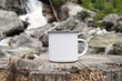 © IndrePau - Blank enamel coffee cup mockup, empty camping mug in wild nature for design presentation.