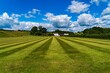 A freshly cut school field on a summers day with clouds in the sky