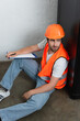 © LIGHTFIELD STUDIOS - Young workman with clipboard sitting on floor