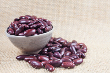 Wall Mural - Red beans in a bowl on a burlap background.