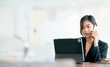 © NAMPIX - Beautiful asian businesswoman using mobile phone and working on computer while sitting at office.