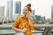 © PinkCoffee Studio - Young beautiful woman talking on the phone, standing on the bridge against Dubai marina