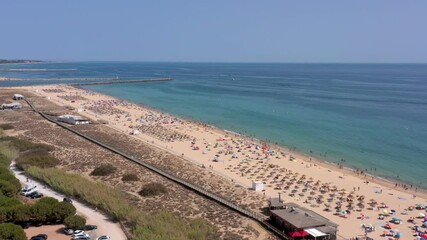 Canvas Print - Aerial video, beautiful Portuguese beaches, near the tourist town, Vilamoura, Falesia, with a view of the dock. Tourists are sunbathing.