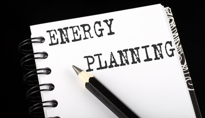 Poster - ENERGY PLANNING written text in small notebook on a black background