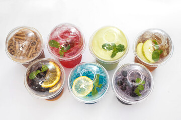 Poster - Top view shot of cold fruit drinks packed in various plastic cups.