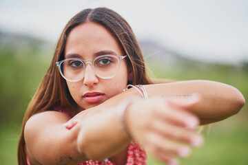 Wall Mural - Portrait of young brunette spanish woman making a pose in green land