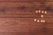 © Sergio Lettieri - Frases de motivación con letras sobre baldosas de madera individuales con un fondo de madera rústica y roble claro.