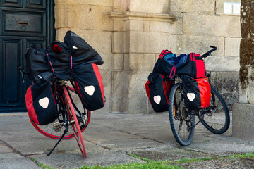 Sticker - Closeup shot of two bicycles with heavy bags parked in front of a building