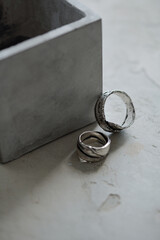 Close-up of two beautiful handmade silver rings near plaster box, jewelry shop concept