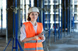 © volody10 - Female construction engineer. Architect with a tablet computer at a construction site. Young Woman looking, building site place on background. Construction concept