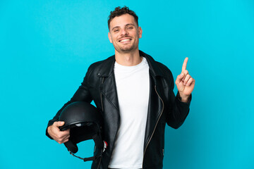 Caucasian man with a motorcycle helmet isolated on blue background showing and lifting a finger in sign of the best