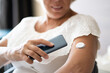 Woman Testing Glucose Level With Continuous Glucose Monitor