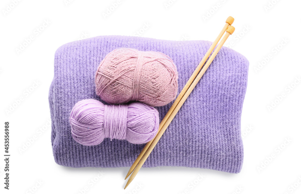Yarn with knitting needles and plaid on white background
