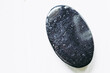 Galet pierre roulée polie tourmaline noire sur un fond blanc - Minéral naturel