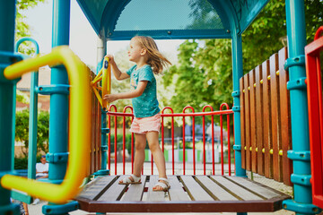 Adorable little girl on playground on a sunny day