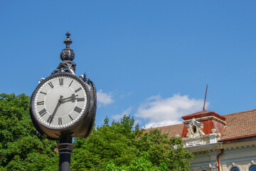 Wall Mural - Metal dial and chairs of a street clock in the park