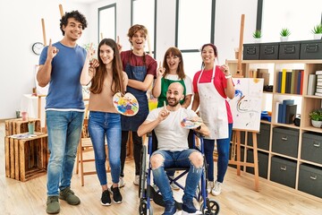 Wall Mural - Group of young artists people at art studio surprised with an idea or question pointing finger with happy face, number one