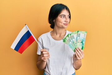 Sticker - Young caucasian woman holding pills smiling looking to the side and staring away thinking.