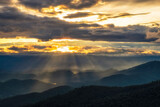 Fototapeta Na sufit - Sunset sky with sun rays over the mountains