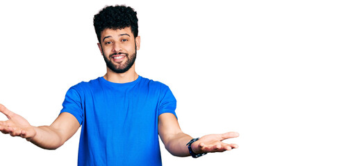 Sticker - Young arab man with beard wearing casual blue t shirt smiling cheerful offering hands giving assistance and acceptance.