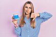 © Krakenimages.com - Beautiful hispanic woman holding earwax cotton removers with angry face, negative sign showing dislike with thumbs down, rejection concept
