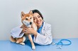 © Krakenimages.com - Veterinarian woman wearing uniform at the clinic, hugging dog with love
