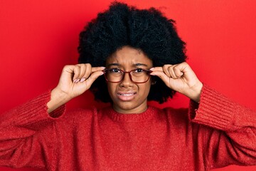 Canvas Print - Young african american woman wearing glasses clueless and confused expression. doubt concept.