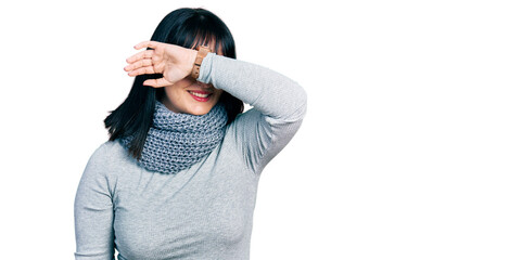 Sticker - Young hispanic plus size woman wearing winter scarf covering eyes with arm smiling cheerful and funny. blind concept.