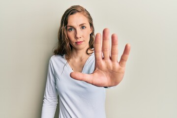 Sticker - Young blonde woman wearing casual clothes doing stop sing with palm of the hand. warning expression with negative and serious gesture on the face.