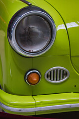 Wall Mural - Closeup shot of an antique lime color car headlight