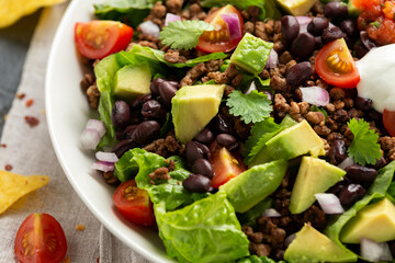 Poster - Beef Taco salad with romaine lettuce, avocado, tomato salsa, black bean and tortilla chips. Mexican healthy food