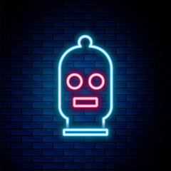 Sticker - Glowing neon line Balaclava icon isolated on brick wall background. A piece of clothing for winter sports or a mask for a criminal or a thief. Colorful outline concept. Vector