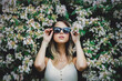 style woman in sunglasses near blooming tree in a grarden in spring time