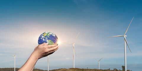 Canvas Print - hands holding globe, earth on wind turbine field background. concept of world environmental protecti