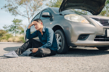 Wall Mural - Serious man headache sitting beside car breakdown on roadside. Car broken concept.