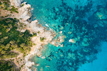 Wall Mural - View from above, stunning aerial view of a green and rocky coastline bathed by a turquoise, crystal clear water. Costa Smeralda, Sardinia, Italy.