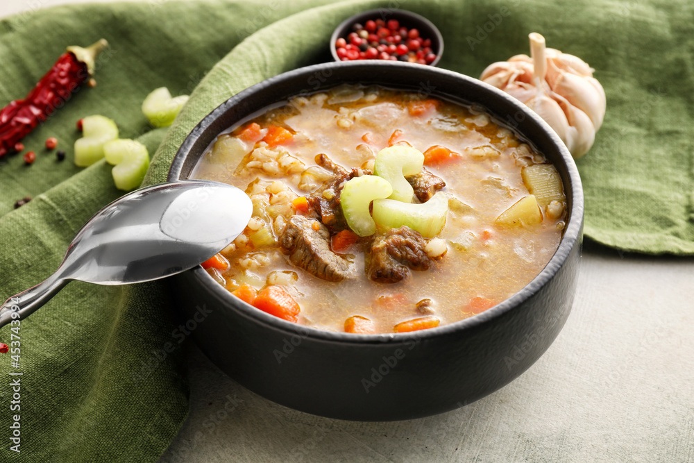 Composition with tasty beef barley soup on grunge background
